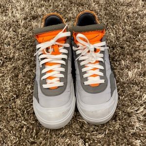 Grey, orange and white Nike shoes.